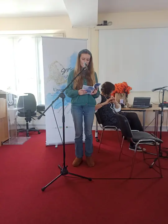 A young writer reading at the microphone