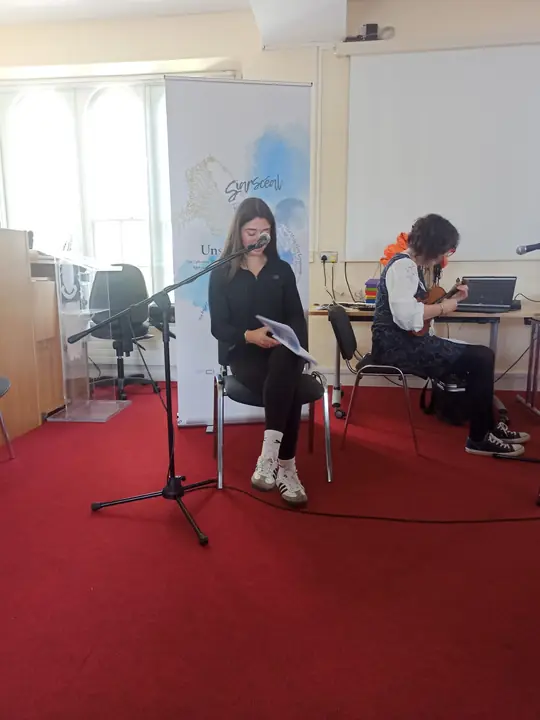 A young writer reading at the microphone