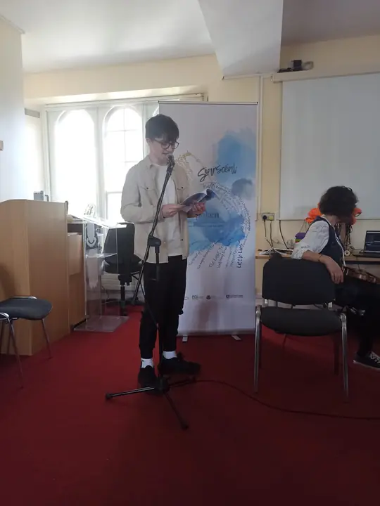 A young writer reading at the microphone
