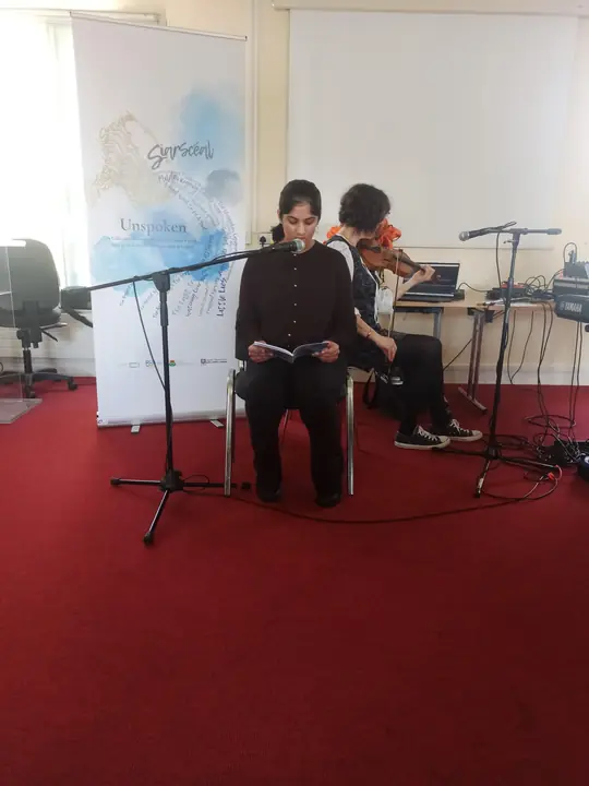 A young writer reading seated at the microphone