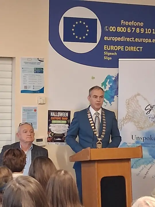 A guest speaking at the lectern while the audience listens